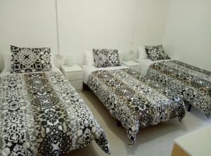 Cette chambre comprend deux lits et un canapé. dans l'établissement Casa Carmen Barcelona, à El Prat de Llobregat