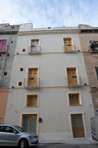 a white building with windows and a car parked in front at Oltremare appartamenti in Trapani