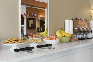 a counter with plates of food and fruit on it at Travelodge by Wyndham Edmundston in Edmundston