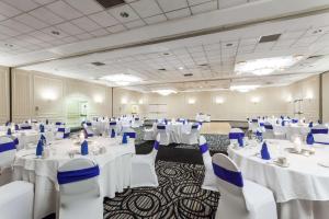 a banquet hall with white tables and blue chairs at Wyndham Southbury in Southbury +34 photos