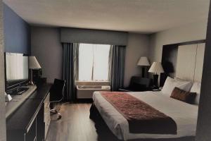 a hotel room with a bed and a television at Wyndham Garden Hotel - Jacksonville in Jacksonville