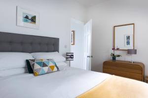 a bedroom with a white bed with a pillow on it at Tregenna Apartments in St Ives