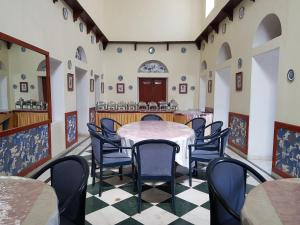 a dining room with a table and chairs at Kesar Bhawan Palace in Mount Ābu