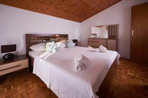 um quarto com uma grande cama branca com toalhas em Apartments Lara em Stobreč