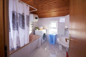 uma casa de banho com um lavatório e uma máquina de lavar roupa em Apartments Lara em Stobreč