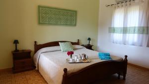 Un dormitorio con una cama con una bandeja de comida. en Agriturismo Marongiu en Villaputzu