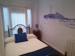 Un dormitorio con una cama con una almohada azul. en Aldatzeta Ostatua en Bermeo