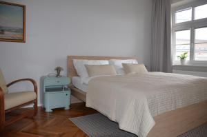 a bedroom with a bed and a chair and a window at Apartmán u Masaryka in Hodonín