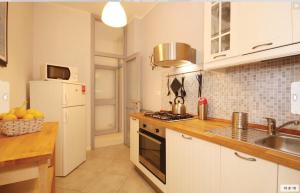 una cocina con fregadero y estufa horno superior en Casa Ilaria, en Viareggio