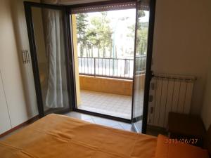 ロゼート・デッリ・アブルッツィにあるDonizetti Apartment 3のベッドルーム1室(ベッド1台付)、バルコニーへのドアが備わります。