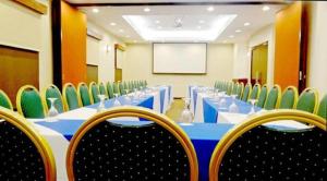 a conference room with a blue table and chairs at Hotel Hex Estelí in Estelí