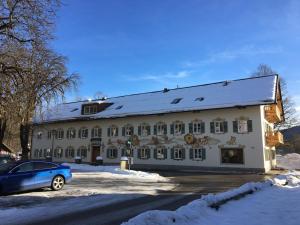 un edificio con un coche aparcado delante de él en Hotel im Sonnental en Jachenau