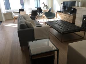 een woonkamer met een bank en een tv bij Appartement in hartje Gent in Gent