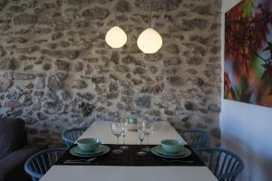una mesa con copas de vino en ella con una pared de piedra en Raval de Ripoll, en Ripoll