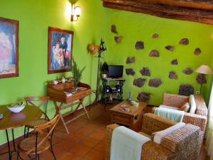 a living room with a green wall with rocks on it at Geranios Rojos II in Las Rosas