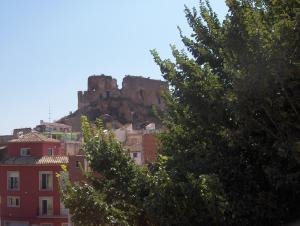 un castillo en la cima de una montaña con edificios en Apartamentos Rurales San Juan, en Castellnovo