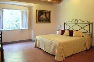 Schlafzimmer mit einem Bett und einem Fenster in der Unterkunft Relais Villa Poschi in Pugnano