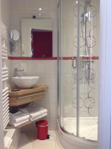 La salle de bains est pourvue d'une douche en verre et d'un lavabo. dans l'établissement Auberge De L'Abbaye, à Hambye