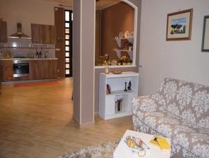 a living room with a couch and a kitchen at Casa Meilikios in Altavilla Milicia