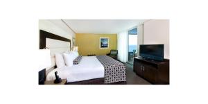 ein Hotelzimmer mit einem Bett und einem Flachbild-TV in der Unterkunft Crowne Plaza Santo Domingo, an IHG Hotel in Santo Domingo