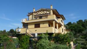 una casa gialla con un balcone sopra di Mare e Monti a Porto Ercole