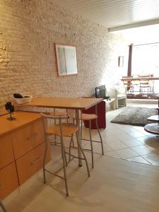 a table and chairs in a room with a brick wall at Maison Arles in Arles