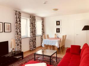 ein Wohnzimmer mit einem roten Sofa und einem Tisch in der Unterkunft Ferienwohnungen Birkenhof in Bad Wörishofen