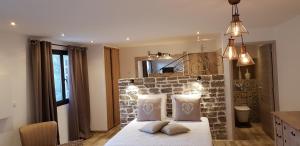 1 dormitorio con pared de ladrillo y cama con almohadas en Maredda 2, en Sartène