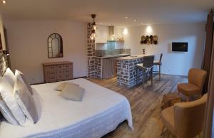 1 dormitorio con 1 cama blanca grande y cocina en Maredda 2 en Sartène