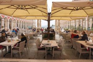 a restaurant with people sitting at tables under umbrellas at Magic Rooms Split in Split