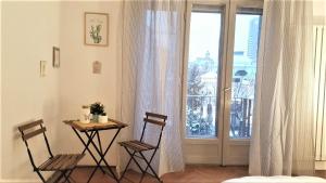 1 mesa y 2 sillas en una habitación con ventana en Studio Central Exer IV, en Bucarest