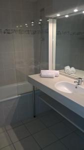 uma casa de banho com um lavatório e um chuveiro em appartement bord de mer em Fouesnant