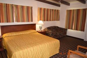 A bed or beds in a room at Stanlunds Inn and Suites