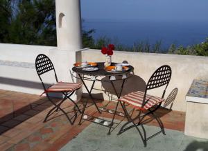 a table with two chairs and a table with food on it at Agriturismo La Dolce Vita Lipari in Lipari
