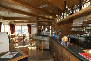 a bar in a restaurant with tables and chairs at Hotel La Tea in Livigno