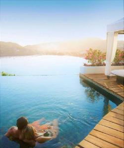 Tentaciones Hotel & Lounge Pool - Adults Only في زيهواتانيجو: رجل وامرأة يسبحان في الماء في المسبح