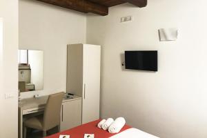 sypialnia z łóżkiem, biurkiem i telewizorem na ścianie w obiekcie B&B Cerasarella w mieście Vibo Valentia