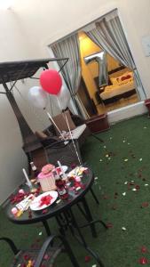 a room with a table with balloons and debris on the floor at Rans Chalets in Taif