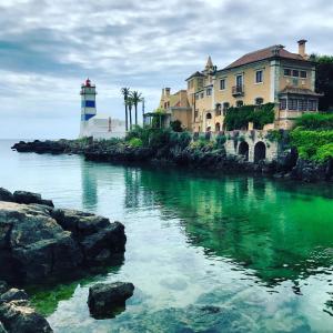 カスカイスにあるApartamento de charmeの水の隣の家と灯台