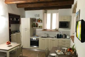 a kitchen with white cabinets and a table and a sink at B&B Cerasarella in Vibo Valentia