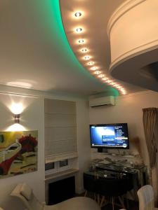 un salon avec une télévision et un plafond vert dans l'établissement Apartment Amorino, à Opatija