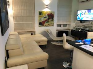 a living room with a white couch and a tv at Apartment Amorino in Opatija