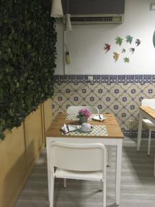 a table with a white chair and a table with flowers on it at Hotel Kamanga in Tomar