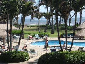 una piscina en el complejo con palmeras en Islander on the Beach Unit 244, en Kapaa