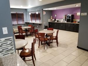 a restaurant with tables and chairs and a kitchen at Super 8 by Wyndham Fort Collins in Fort Collins