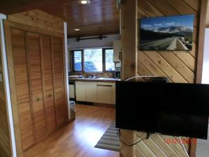 eine Küche mit Holzwänden und einem Flachbild-TV in der Unterkunft Invermere Luxury 4 Bedroom Mountain Lake View Home - Sleeps 8, 2 decks, Huge Yard, Walk to Town -Beach, Tennis, Golf at 12 Courses - Hot Springs Close By!! in Invermere