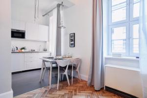 una cocina blanca con mesa y sillas. en "Apartament na Kazimierzu" en Cracovia