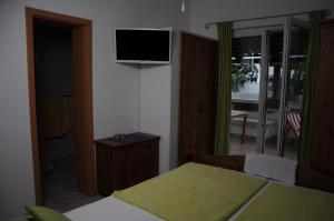 a bedroom with a bed and a television on the wall at Villa Delfin in Sutivan