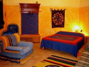 a bedroom with a bed and a chair at Agriturismo La Dolce Vita Lipari in Lipari