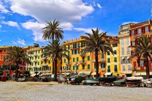 a group of buildings with palm trees and boats at Due balconcini sul mare in Santa Margherita Ligure